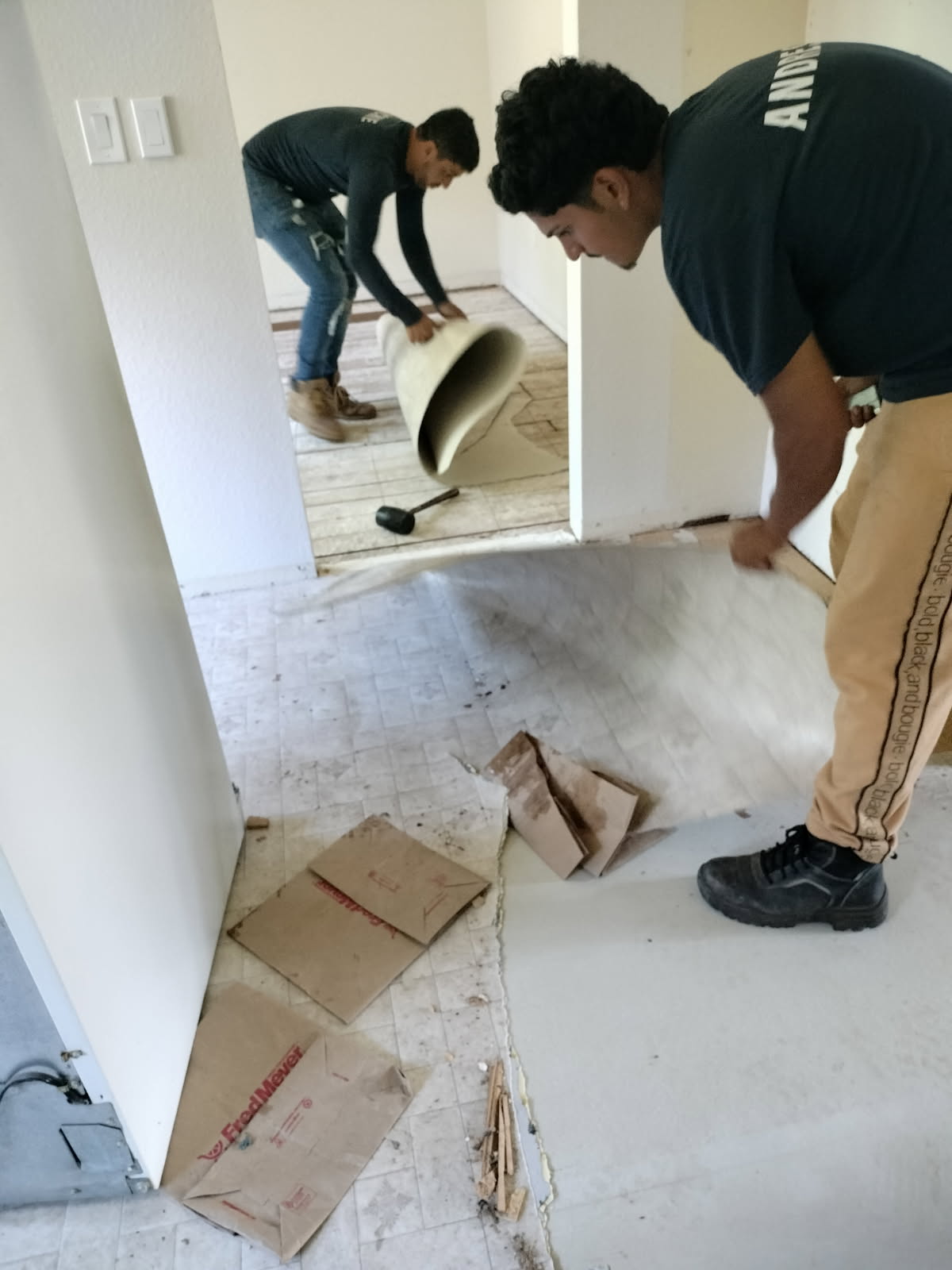 Crew tearing out old flooring during a renovation cleanout