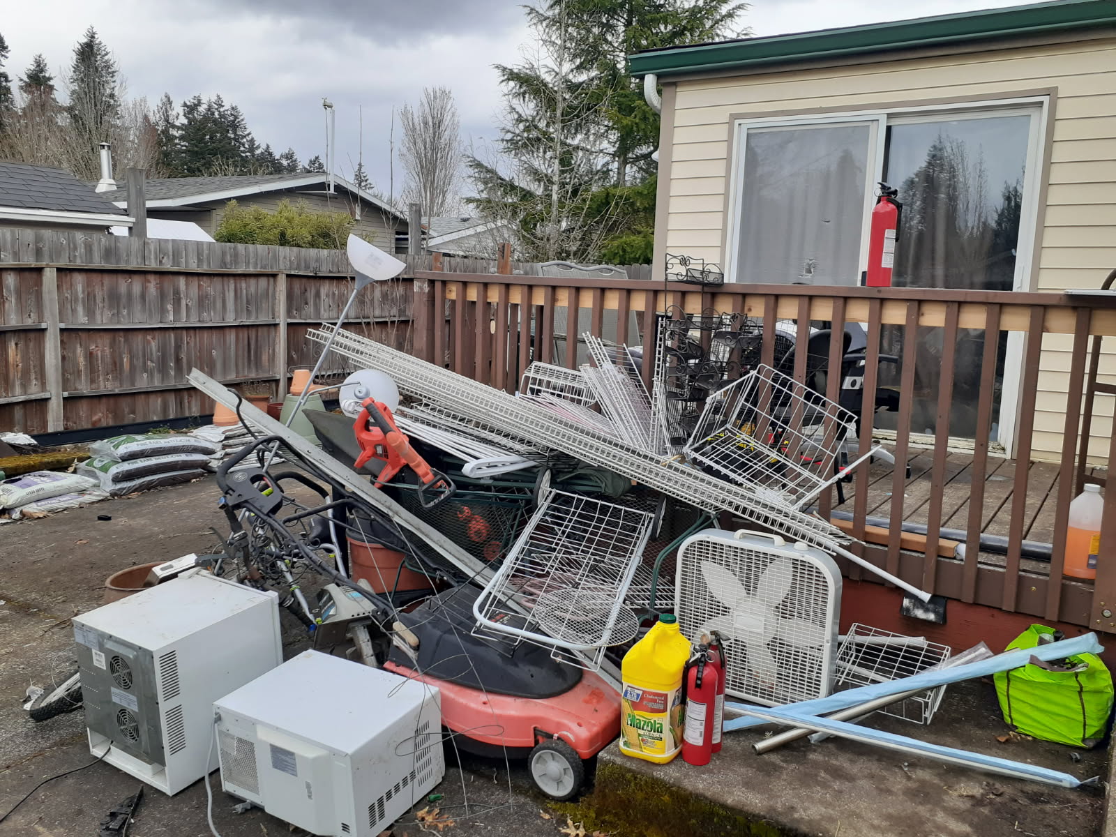 Whole-deck cleanout — appliances, shelving, and household clutter staged for haul