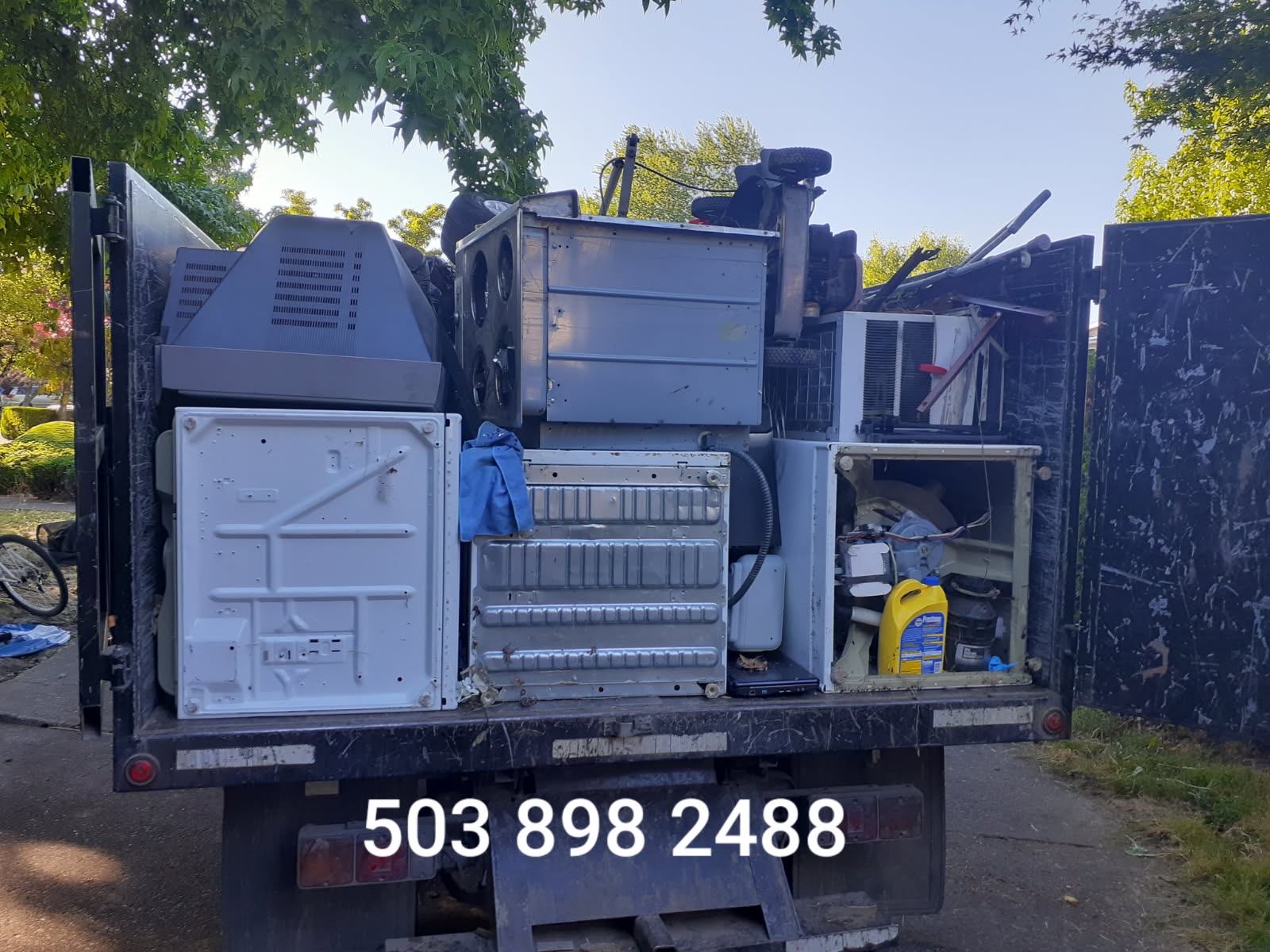 Dump It Express truck loaded with washers, dryers, and household appliances